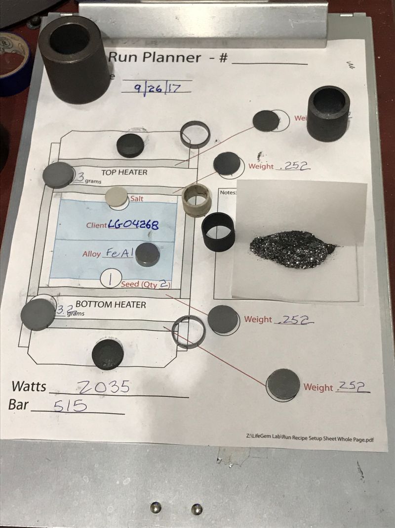 クライアント番号が記載された管理シートの上に配置された、ダイヤモンド結晶化のための炭素と金属材料