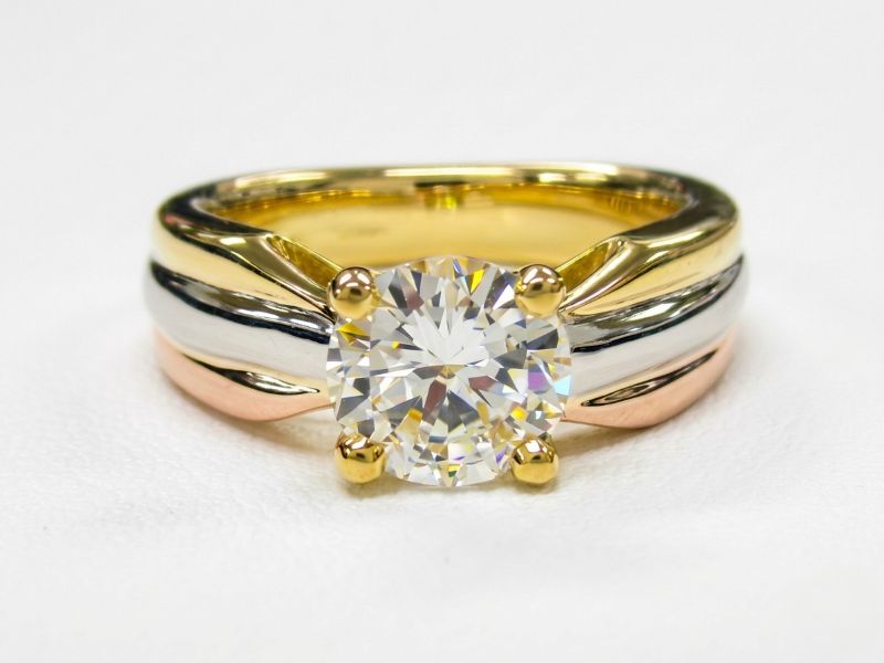 イエローゴールド、プラチナ、ピンクゴールドの3色を組み合わせた、リボンのような曲線が特徴のメモリアルダイヤモンドリング（MDR-105）