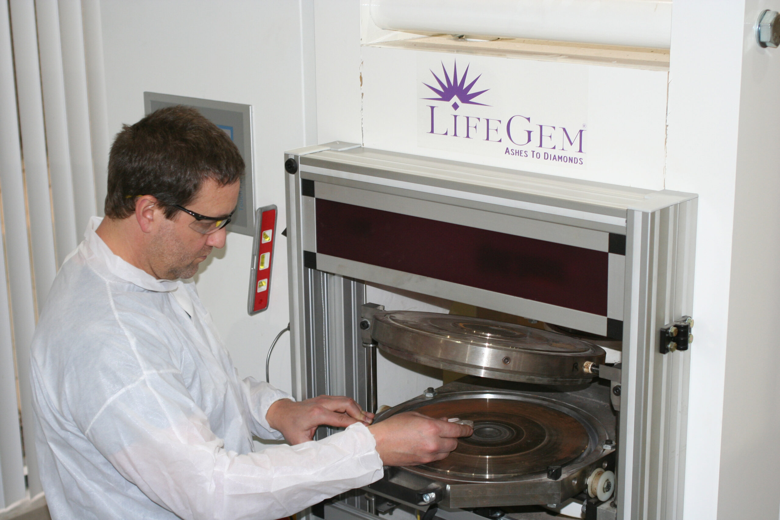 ライフジェム専用の超高圧・高温装置（プレス機）を調整する熟練技術者の様子